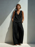 Woman wearing a black linen-blend buttoned vest with wide leg pants.