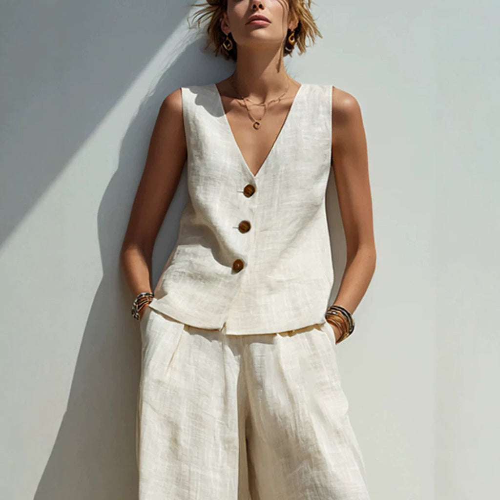 Woman wearing a white linen-blend buttoned vest with wide leg pants.