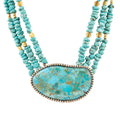Turquoise beaded statement necklace with large turquoise stone pendant and gold accents.